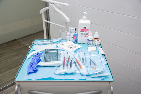 Moscow, Russia - March 23, 2021: Sterile medical instruments in packaging and blue and black disposable gloves in a medical office. Surgical and dentistry equipment on the table.のeditorial素材