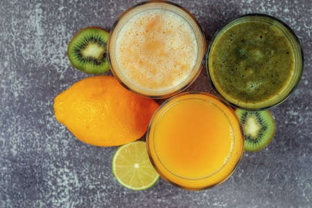 Top view of glasses of orange juice and banana kiwi and spinach smoothies.の写真素材