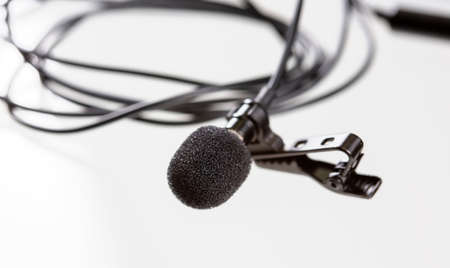 Small lavalier microphone or lapel mic with clip on white background. Professional sound recording equipment for cell phone.の写真素材