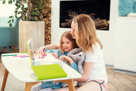 Happy Caucasian Mom With Daughter Sitting On The Living Room Floor And Drawing Together, Spending...