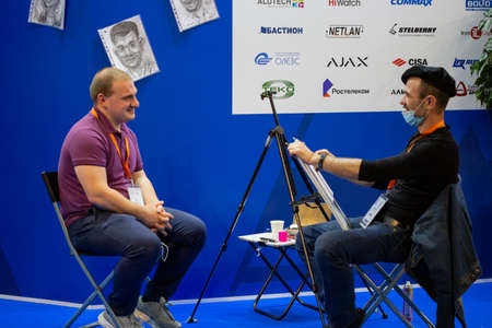 Moscow, Russia - 14 april 2021: A street artist doing portrait with a simple pencil in a recreation area at an exhibitionのeditorial素材