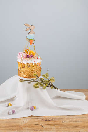 Easter cake with decorative wooden ornament in the form of a rabbit, dried oranges and a sprig of...
