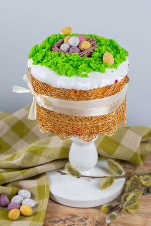 Easter cake made from yeast dough, decorated with edible moss with a nest and chocolate eggs. Easter...