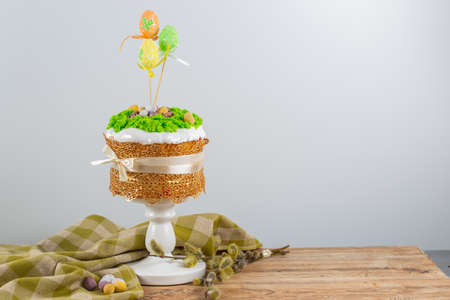Easter cake made from yeast dough, decorated with edible moss with a nest and chocolate eggs. Easter...