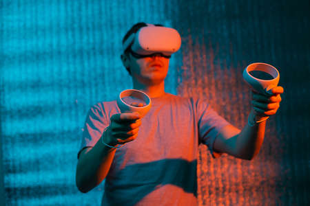Caucasian man 25-30 years in vr glasses, playing video games with virtual reality headset, trying to...