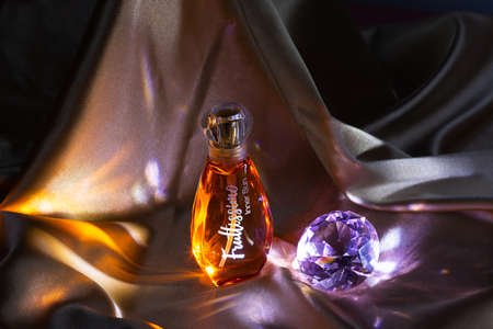 Moscow, Russia - July 12, 2021: A bottle of toilet water on a gold satin fabricのeditorial素材