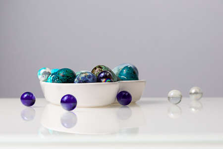 Easter blue quail eggs in a plate in the shape of a heart on a white table.の写真素材