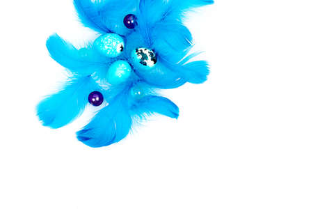 Blue Easter eggs and small fluffy blue feathers randomly scattered on white tableの写真素材
