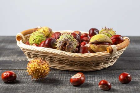 Chestnuts in a basket on a wooden background.の写真素材