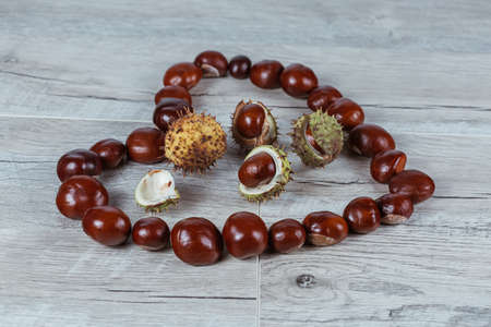 Chestnuts in a heart shape on a wooden background.