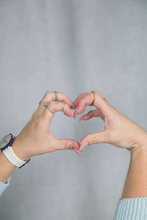 Women's hands with beautiful manicure and rings are folded in a beautiful gentle elegant gestureの写真素材