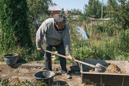 Kneading cement for pouring garden path, garden construction work.の写真素材