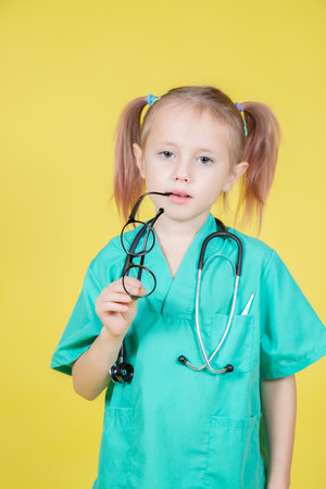 Portrait of serious little caucasian kid dressed in doctors green coatの写真素材