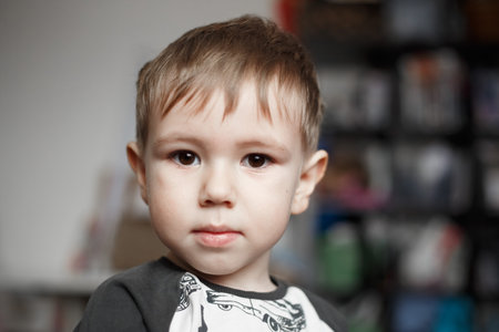 Little Caucasian boy looking at camera, lifestyle photography at homeの写真素材