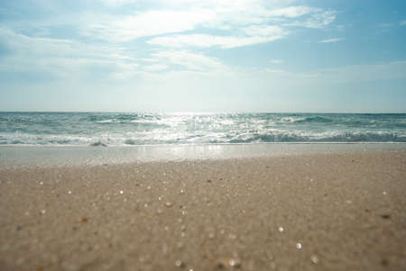 Panoramic shot of an ocean waves, beautiful sand sparkling at the sun.