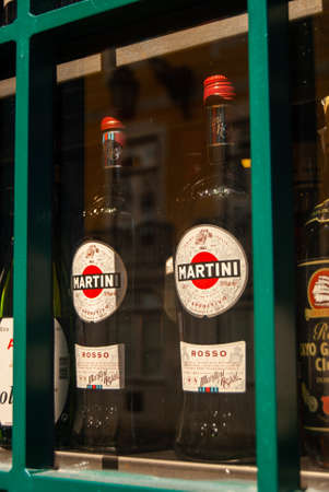 Lisbon, Portugal - July 29, 2021: Two Martini Rosso bottles on a vintage shelf on a green crossed window displayのeditorial素材
