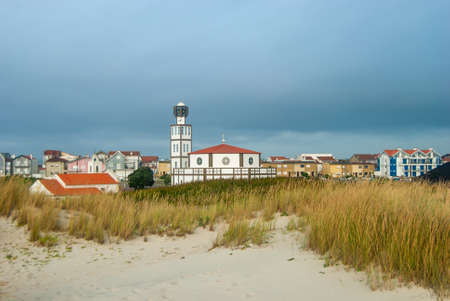 Modern Igreja Matriz of Costa Nova among beach dunes and famous colorful striped houses before the storm - Costa Nova, Portugalの写真素材