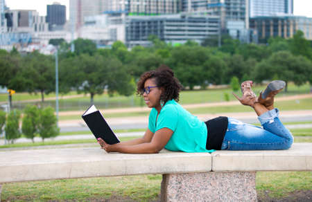 Beautiful African American woman reading a bookの写真素材