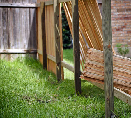 Backyard with lumber for new privacy fence, old fence and partially built new fenceの写真素材