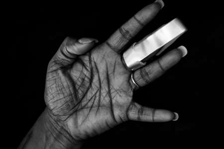 Nicely manicured hand of African-American woman with cast for arthritis or fractured finger
