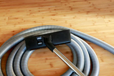 Beautiful bamboo hardwood floor with a central vacuum cleanerの写真素材