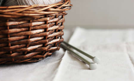 Wooden basket with wool yarn and needles. Close upの写真素材