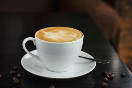 The cup of coffee on the black table in cafe