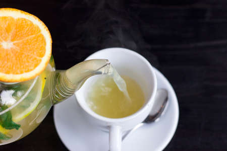 Orange herbal hot tea poured into the cup. Close upの写真素材