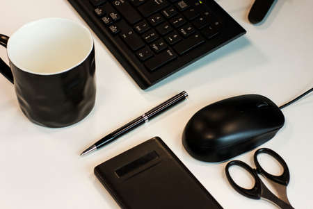business still life: keyboard, mouse, pen, scissors, calculator and black cupの写真素材
