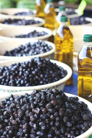 Black pickle olives in bowls and bottles with olive oil at the eastern marketの写真素材