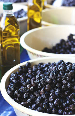 Black pickle olives in bowls and bottles with olive oil at the eastern marketの写真素材