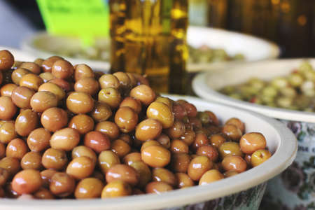 Green pickle olives in bowls and bottles with olive oil at the eastern marketの写真素材