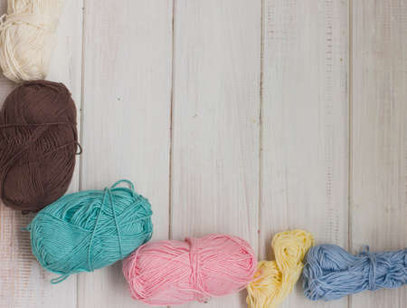 Colored cotton yarn on white wooden background. Copy space
