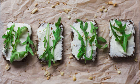 Vegetarian sandwiches on grain bread with ricotta cheese, walnuts and arugulaの写真素材