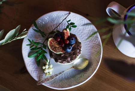 Chocolate cupcake with figs and berries on wooden table. View from topの写真素材