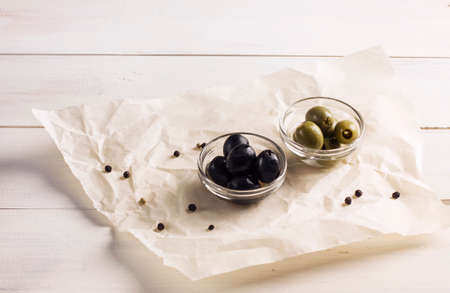 Green and black pickled olives on a white backgroundの写真素材