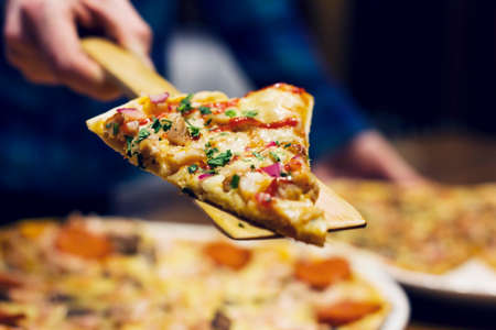 The lifting slice of hot pizza, closeupの写真素材