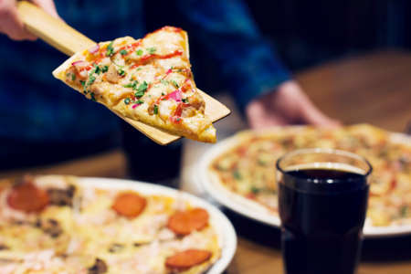 The lifting slice of hot pizza, closeupの写真素材