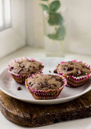Homemade muffins with chocolate on old wooden Board