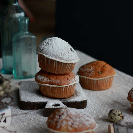 Homemade muffins with sugar powder icing on old wooden Boardの写真素材