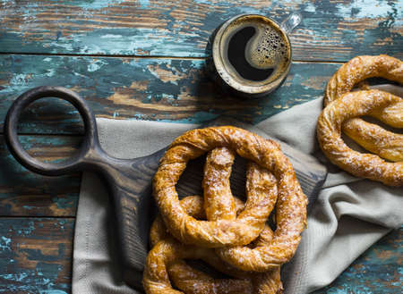Fresh baked pretzels and coffee on shabby wooden blue backgroundの写真素材