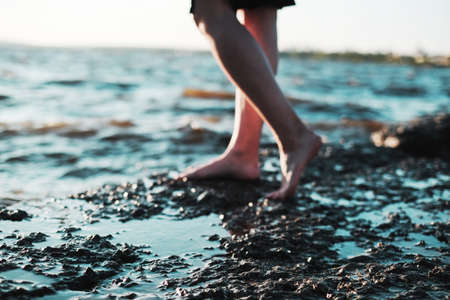 Women bare feet by the sea at sunset, selective focusの写真素材