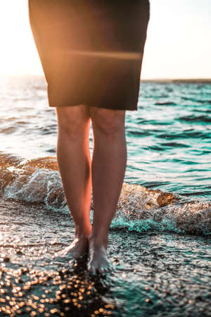 Women bare feet by the sea at sunset, selective focusの写真素材