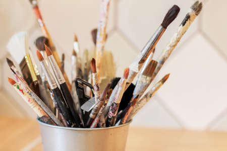 Different brushes of the artist in a metal bucket, selective focus