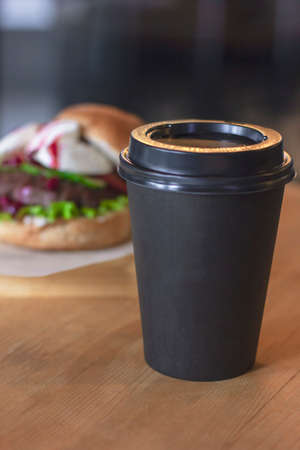 Black Cup with coffee to go on background with burger, mock upの写真素材