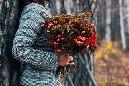 Girl holding hands in autumn and winter forest bouquet, diyの写真素材