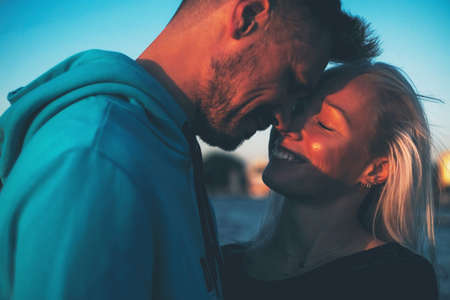 Silhouette of couple in love on the pier, sunset time, water backgroundの写真素材