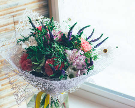 Beautiful rustic summer bouquet of different flowers in floral paperの写真素材