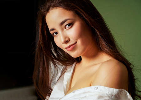 Beauty fashion portrait of sexy sensual smiling asian young woman with dark long hair in white shirt...