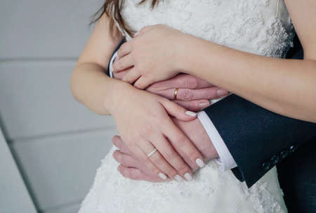 Man holding woman's hand with engagement ring, wedding day